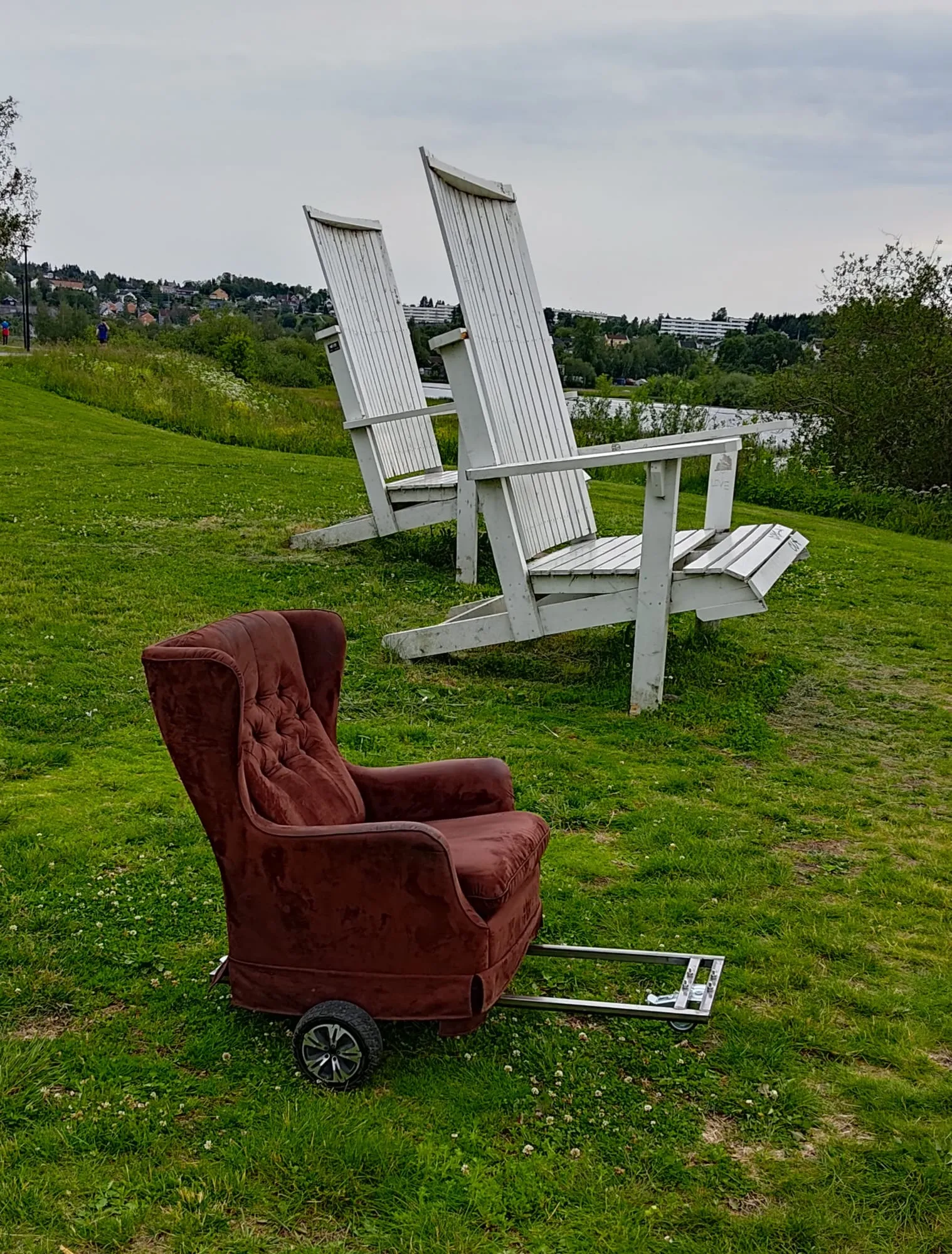 The armchair on the grass next to the giant white chairs