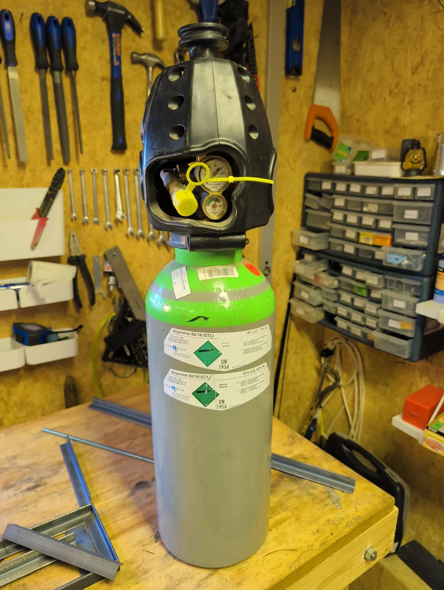 The MiniBertha bottle of Argonmix 82/18 on the bench, with the regulator gauges inside its protective cap